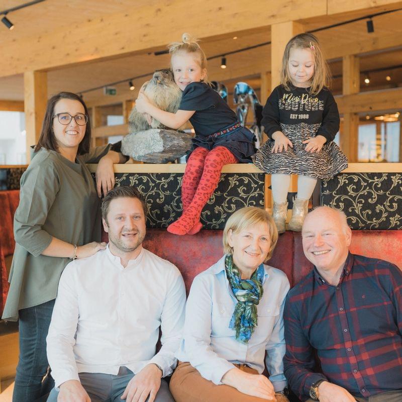 Familienfoto mit drei Generationen in einem gemütlichen Holzrestaurant
